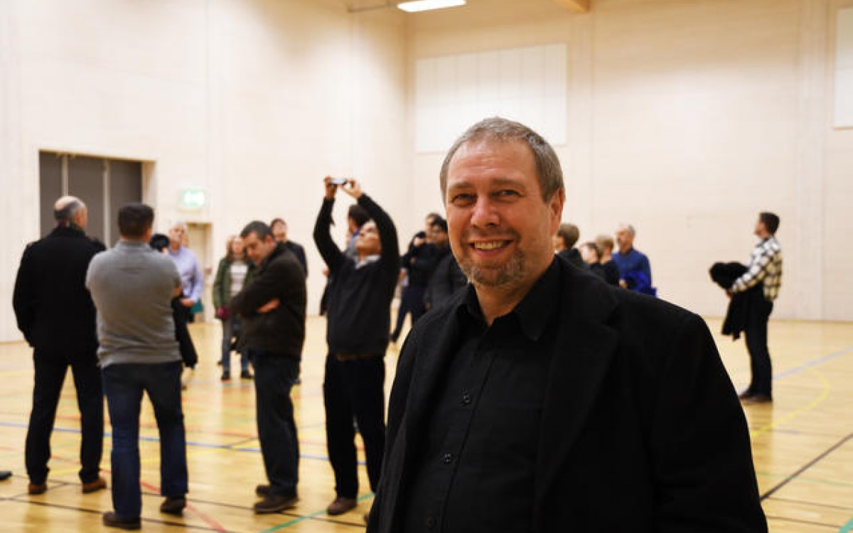 Bjarne Lindeløv er for tiden vertskap for en rekke gjester fra mange land. I bakgrunnen blir Bankgata flerbrukshall tatt i øyensyn av interesserte besøkende. Foto: Thoralf Fagertun